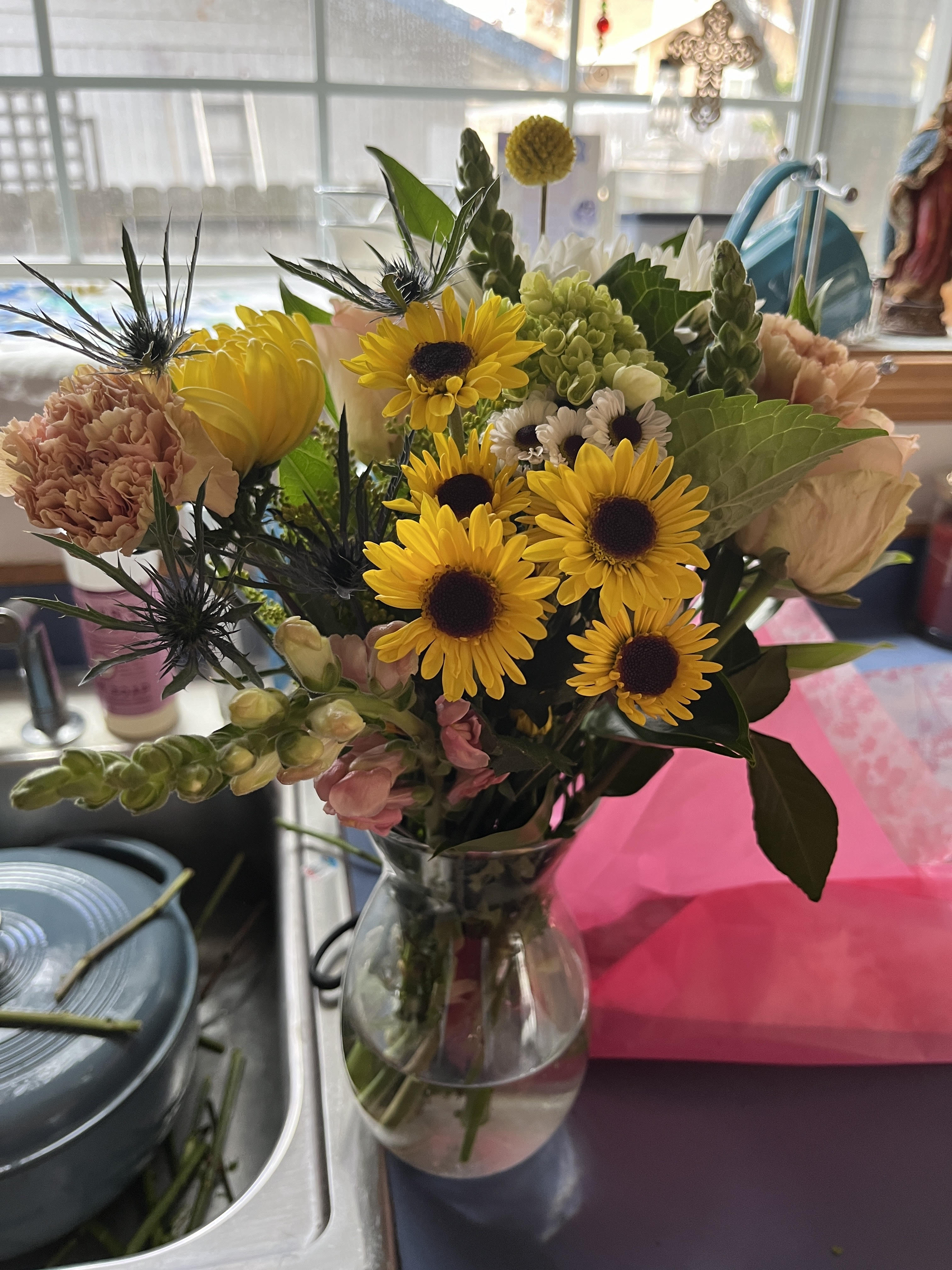 A picture of a bouquet of flowers in a vase sitting on the kitchen counter
